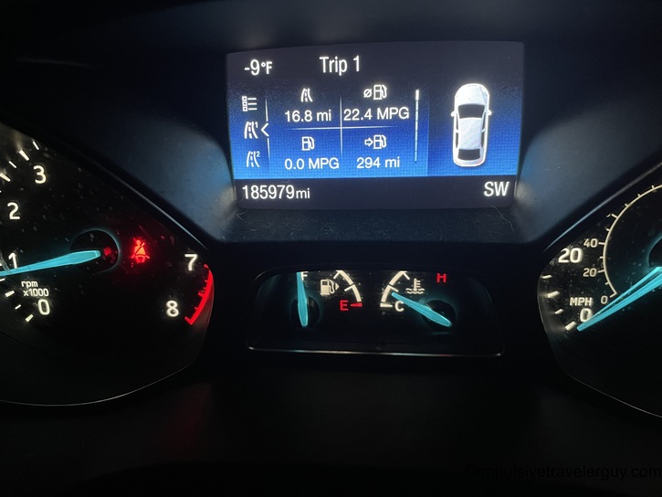 A car dashboard display showing an exterior temperature of -9°F, with trip computer data showing 22.4 MPG, 294 miles of range, and an odometer reading of 185,979 miles.