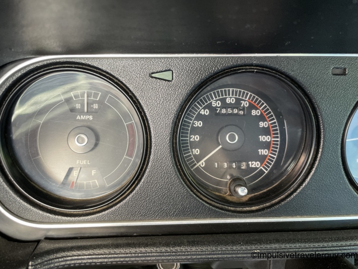 Close-up of the Cougar's amps and fuel gauges while parked — ammeter centered, fuel gauge needle sitting near empty after the road trip, with the speedometer showing 78,599 miles.