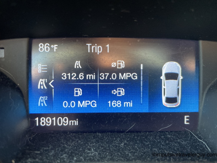 Car dashboard trip computer showing 189,109 total miles, 86 degrees outside, 312.6 miles on the trip at 37.0 MPG with 168 miles of range remaining.