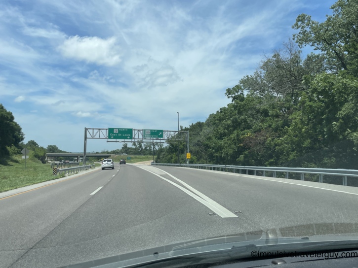 Highway interchange with overhead signs for Route 3 North to East St. Louis and Route 158 East to Belleville, Illinois.