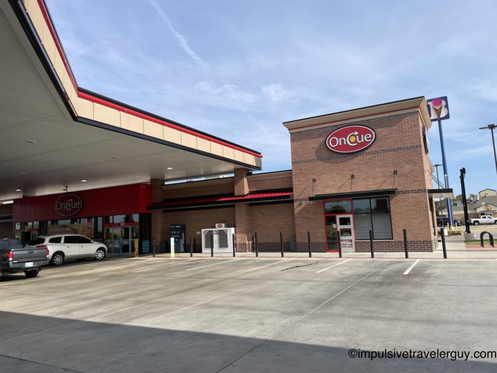 Exterior view of an OnCue gas station and convenience store featuring a red brick building and gas canopy.