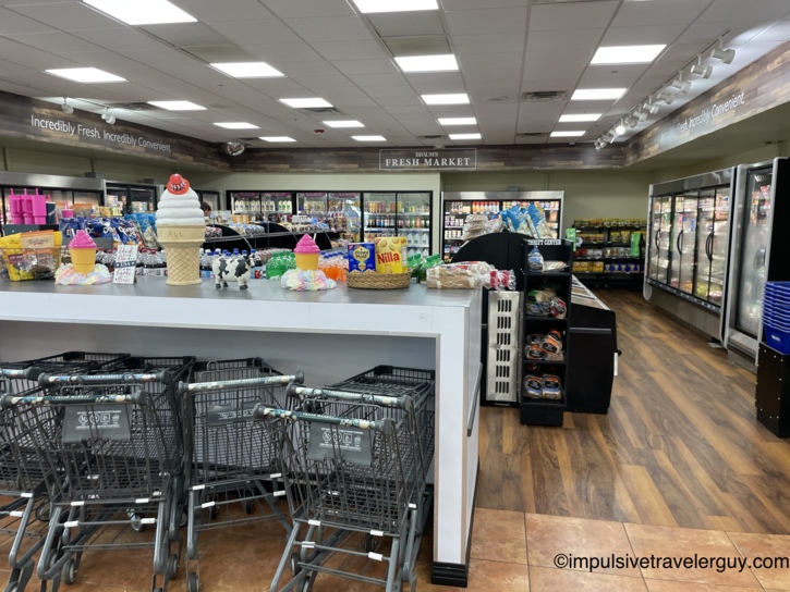 Interior of the Braum's Fresh Market grocery section showing shopping carts and refrigerated display cases.