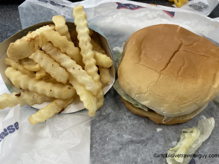 A Braum's fast-food meal consisting of a hamburger and a side of crinkle-cut french fries.
