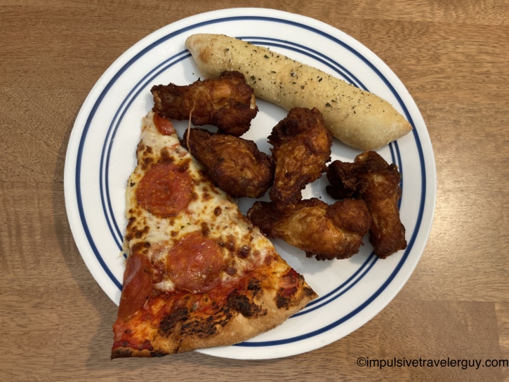 A takeout meal from JonnyO's consisting of a slice of pepperoni pizza, fried chicken wings, and a breadstick.