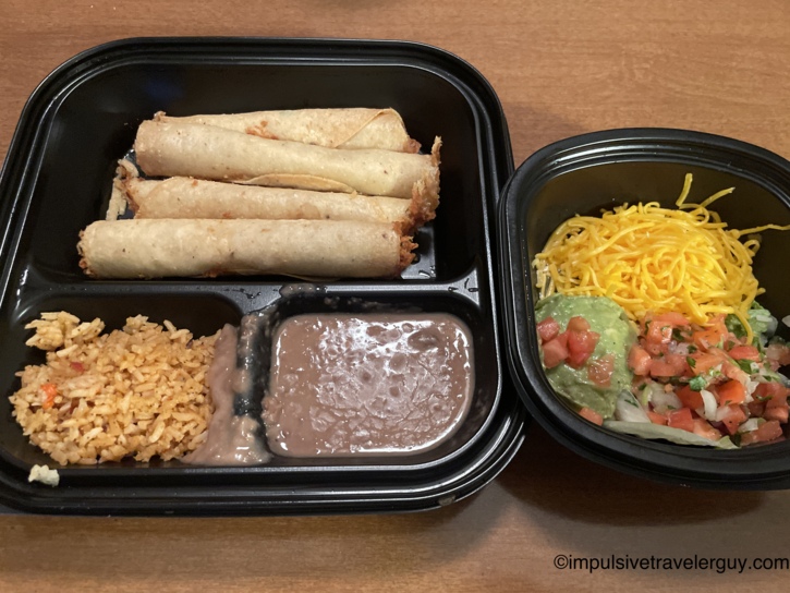 Takeout containers from Lupe Tortilla holding a Mexican meal of flautas, rice, refried beans, and a side salad with guacamole.